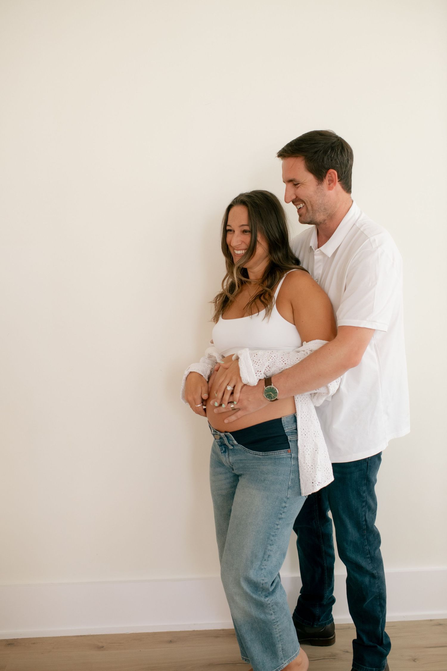 A couple shares loving moments during a minimalist indoor photoshoot.