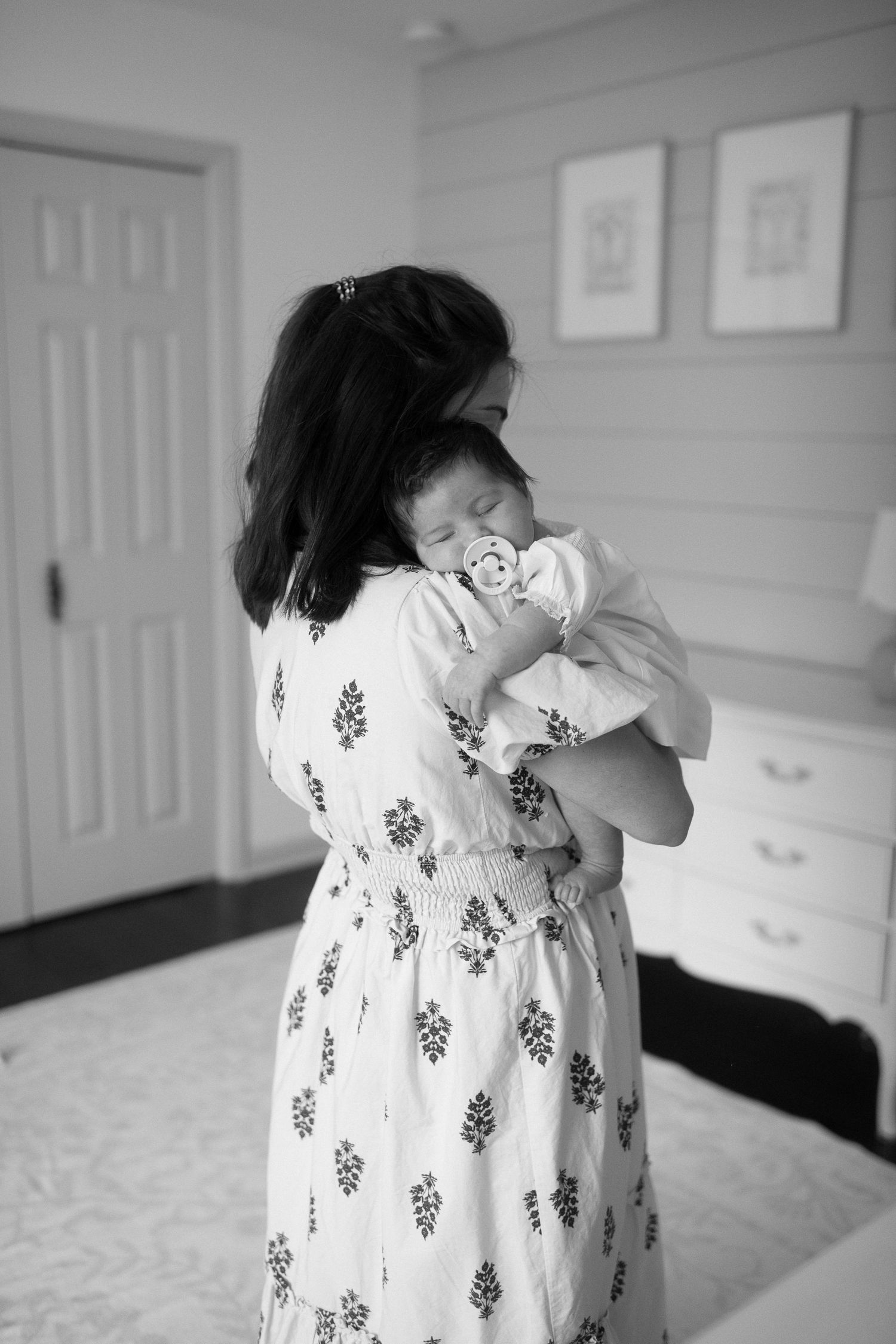 Tender moments between family members and their newborn in black and white photography.