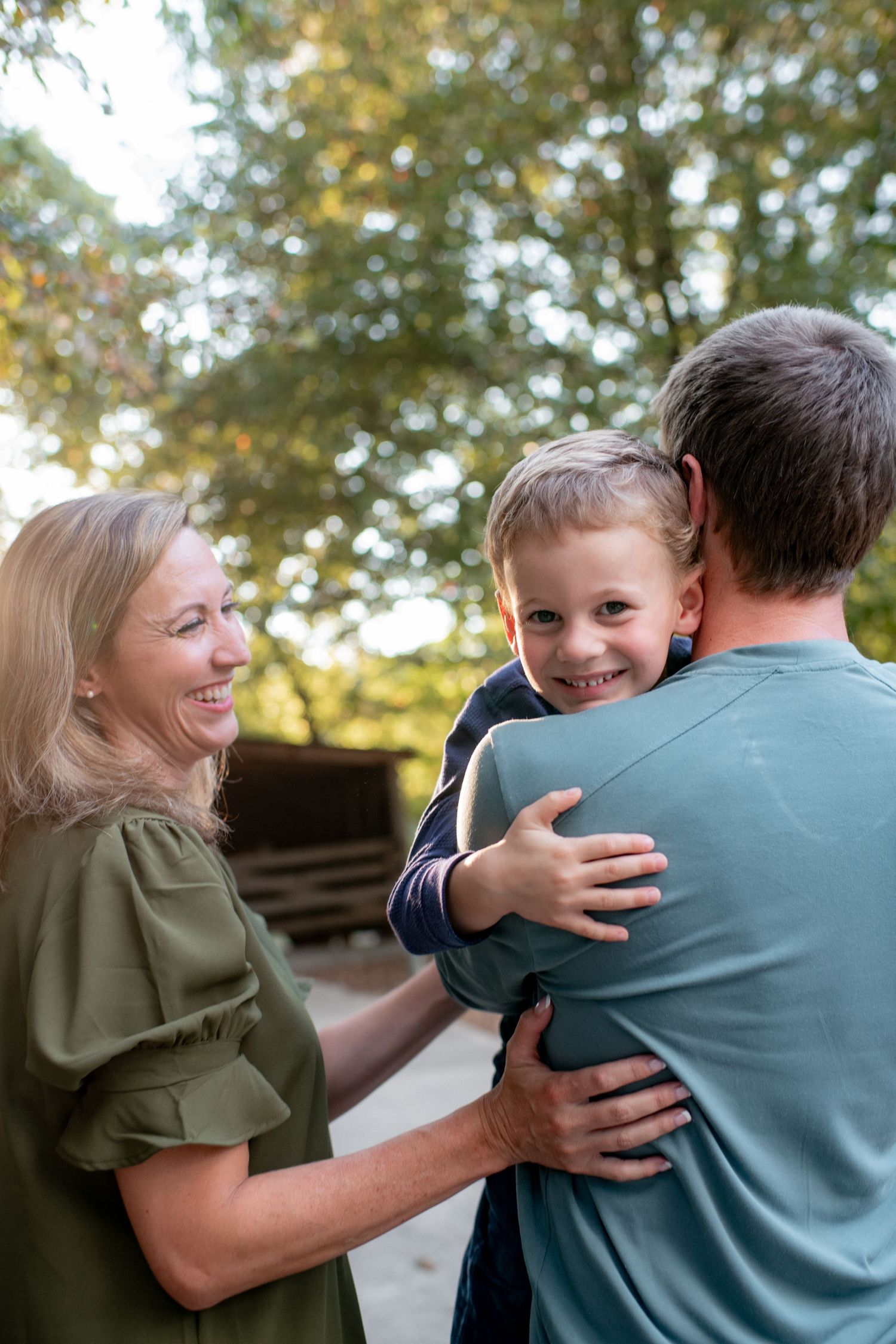 A joyful outdoor family photoshoot sequence showing playful interaction and laughter.