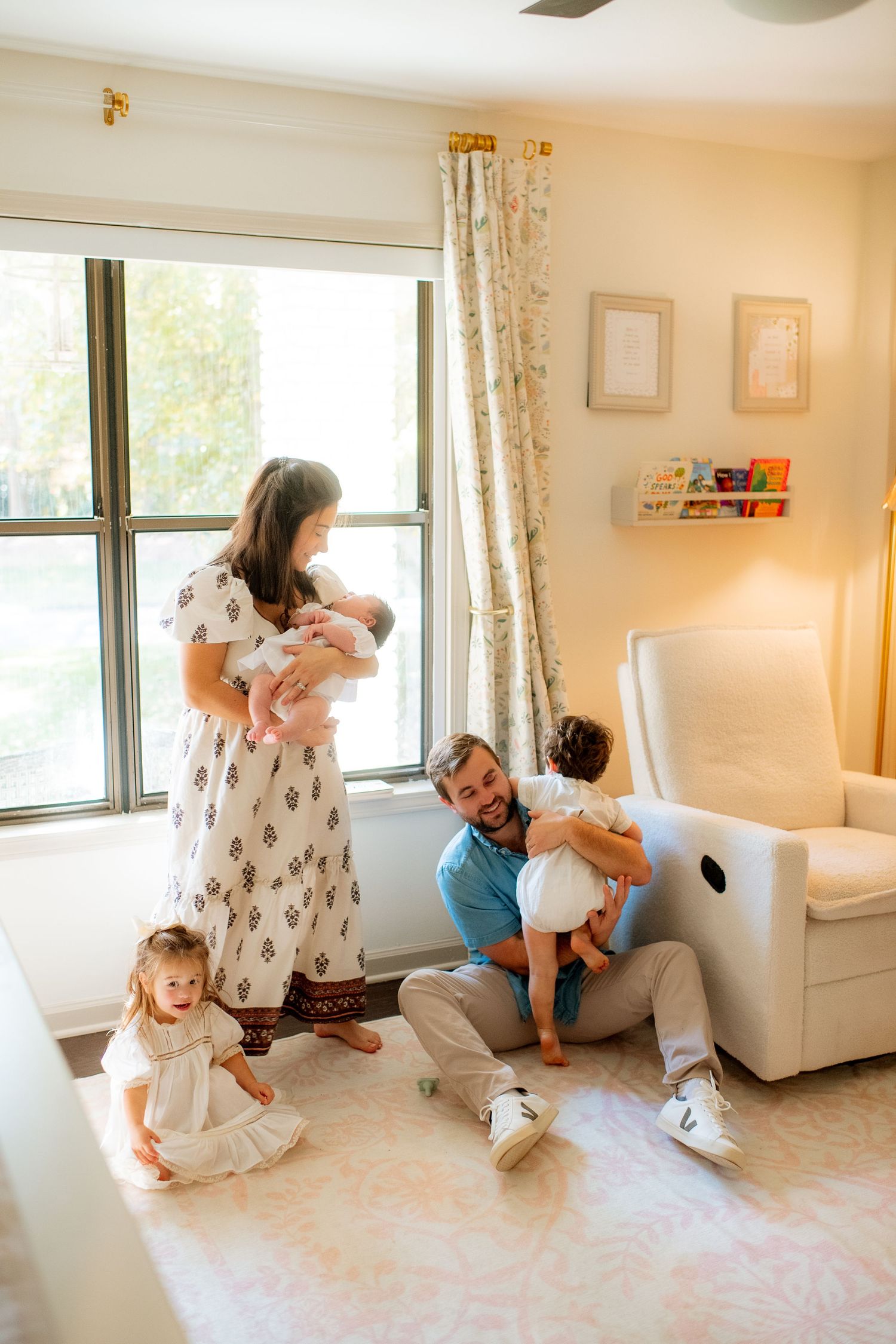 Playful family moments captured in a bright living room with white furniture and natural lighting.