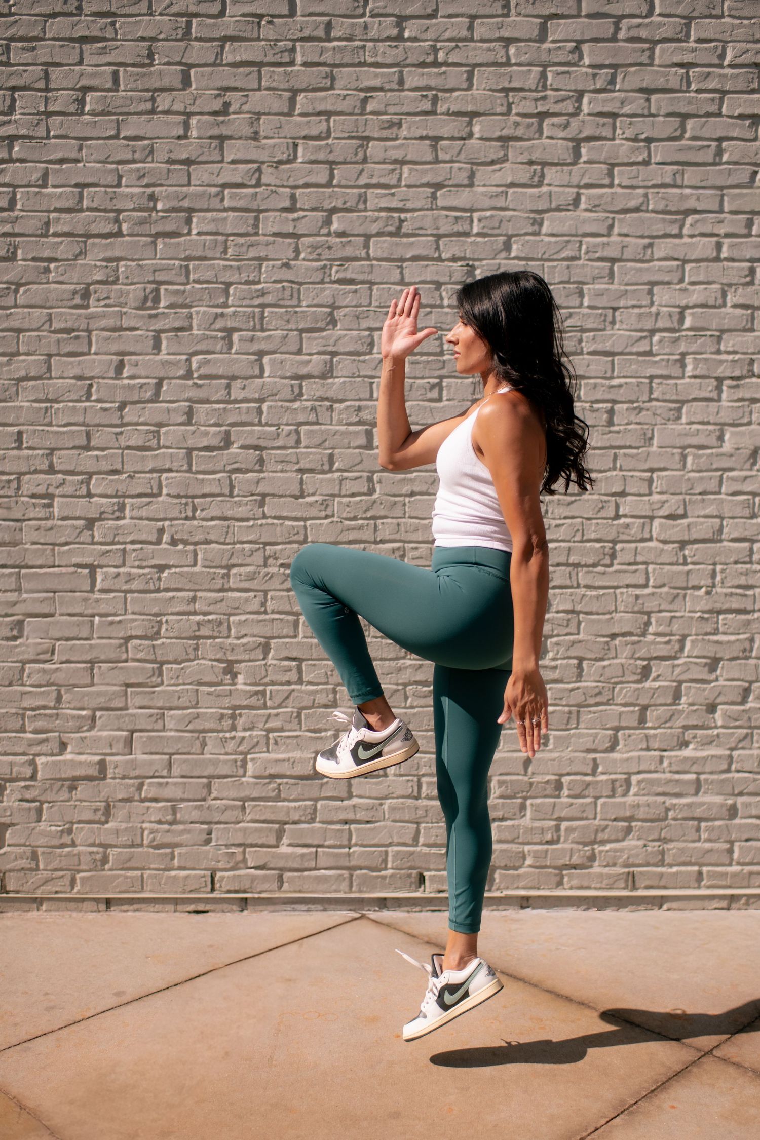 A sequence of dynamic dance poses against a brick wall showcasing fluid movement and balance in athletic wear.