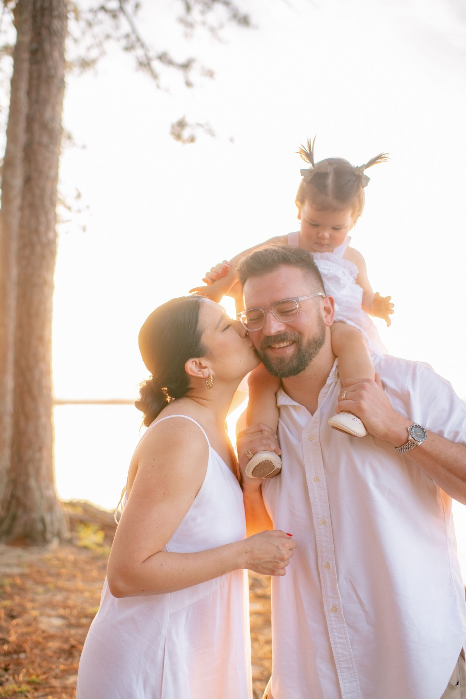 Family sharing joyful embraces during sunset beach photoshoot.