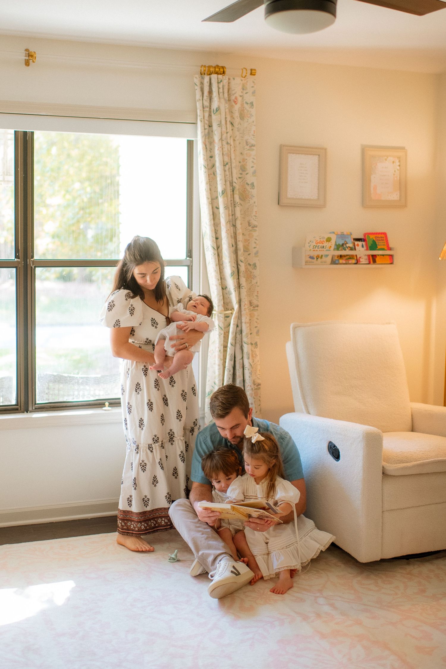 A family gathers in a sunlit nursery, sharing stories and precious moments together.