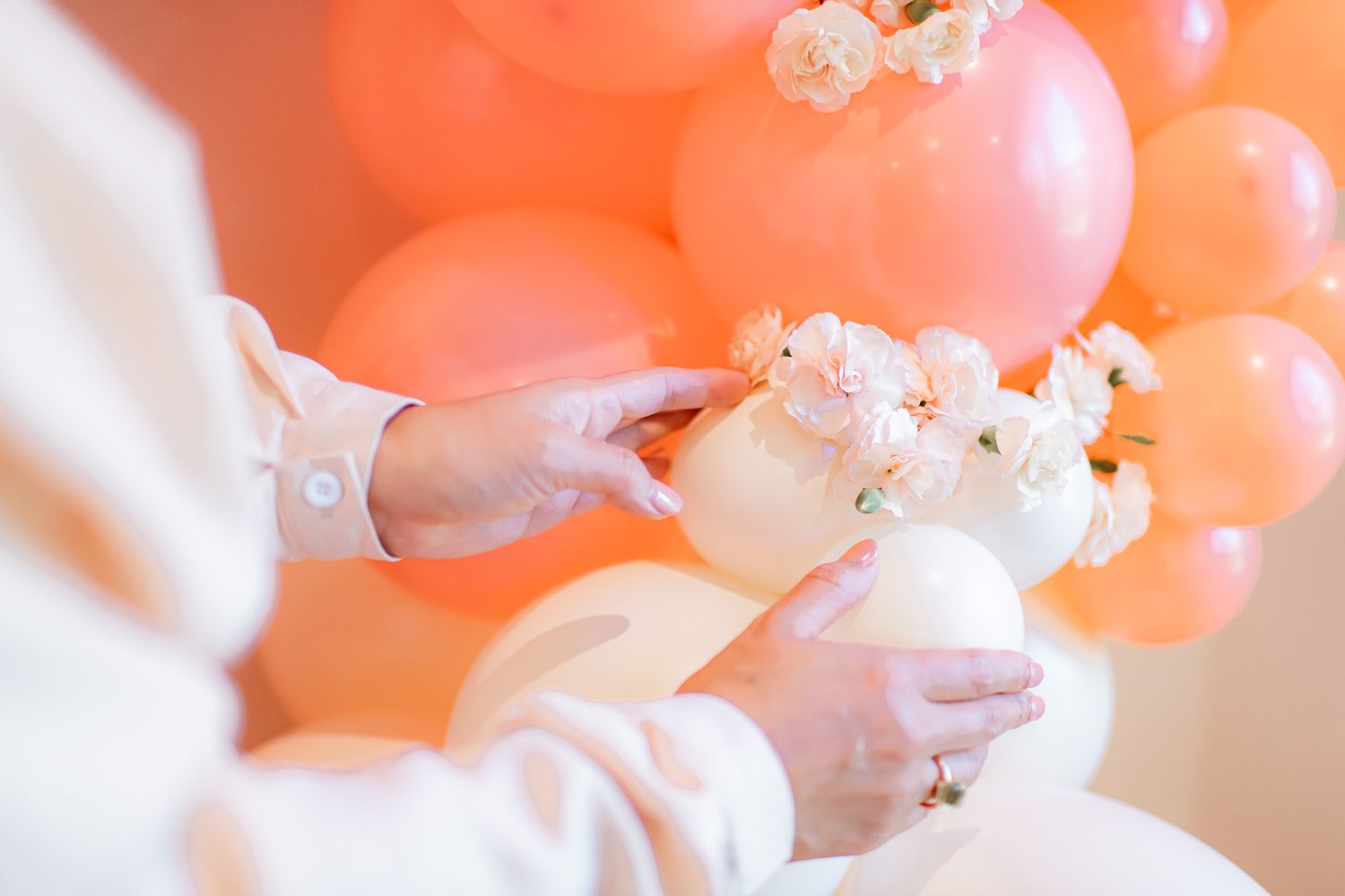 Delicate white popcorn flowers bloom against a soft peach-colored background creating a dreamy romantic atmosphere.