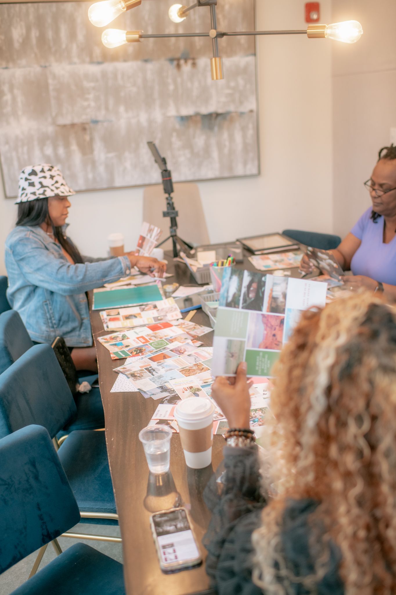 A group gathered around a table working on creative paper crafts and scrapbooking projects.