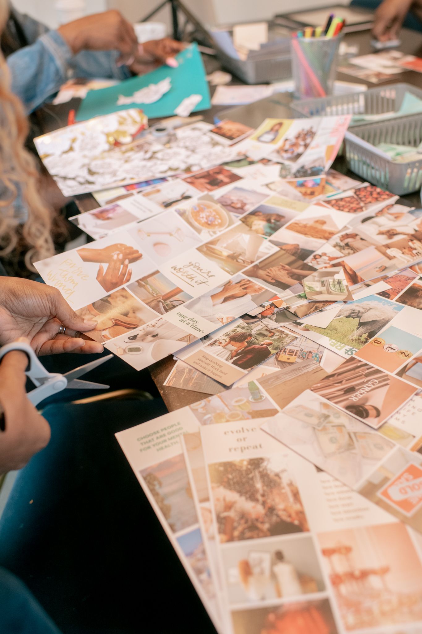 Collection of vintage photographs and postcards spread across a wooden table surface.