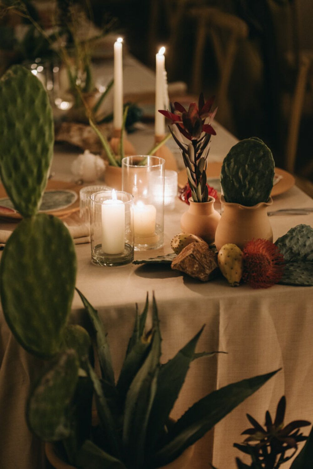 Moody wedding table decor with candlelight, succulents, and desert-inspired elements.