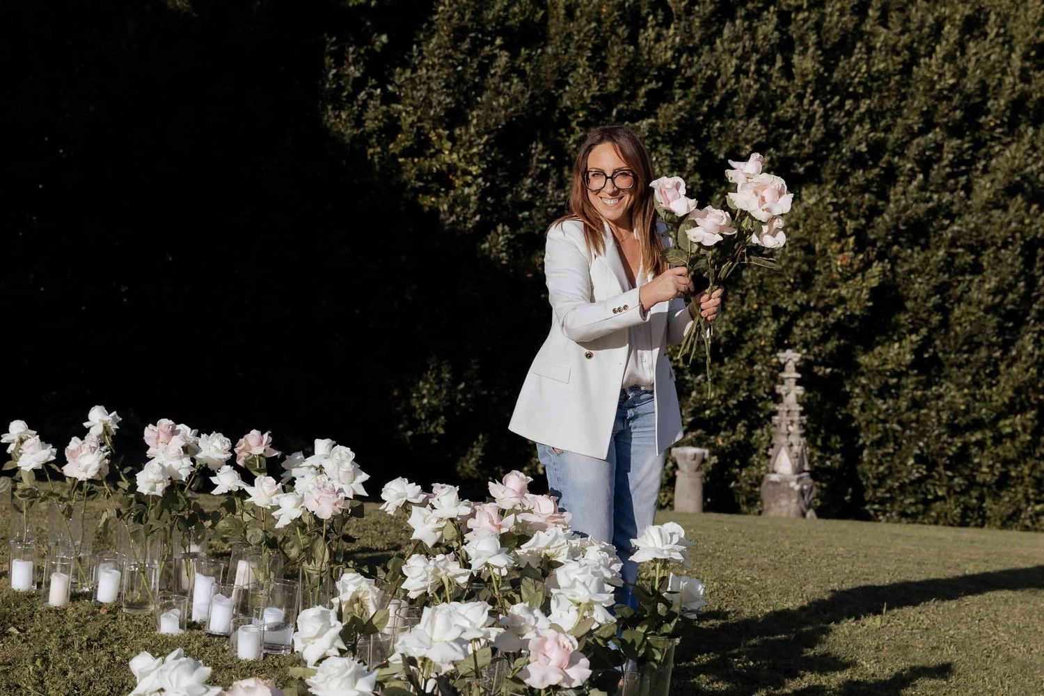 White floral arrangements with orchids displayed in an outdoor garden setting.