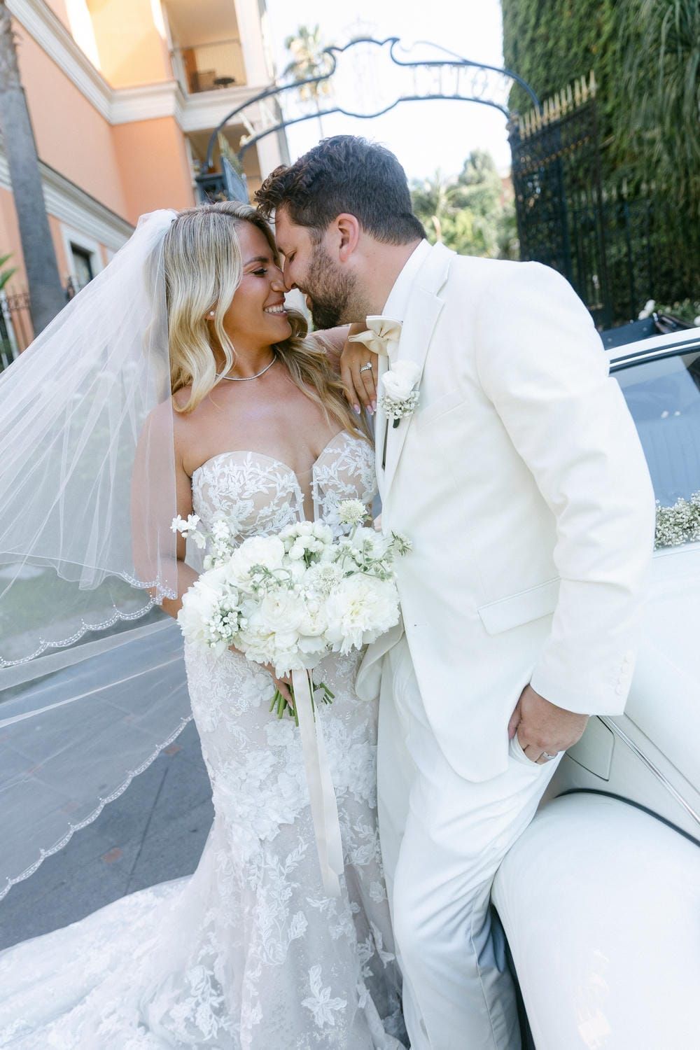 A romantic wedding couple shares intimate moments in a series of outdoor photos wearing white attire with a flowing veil.