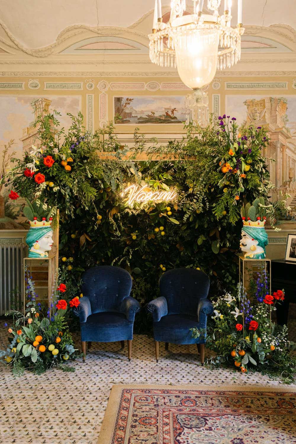 Luxurious event space decorated with lush floral arrangements and crystal chandeliers. Luxury event floral design Italy
