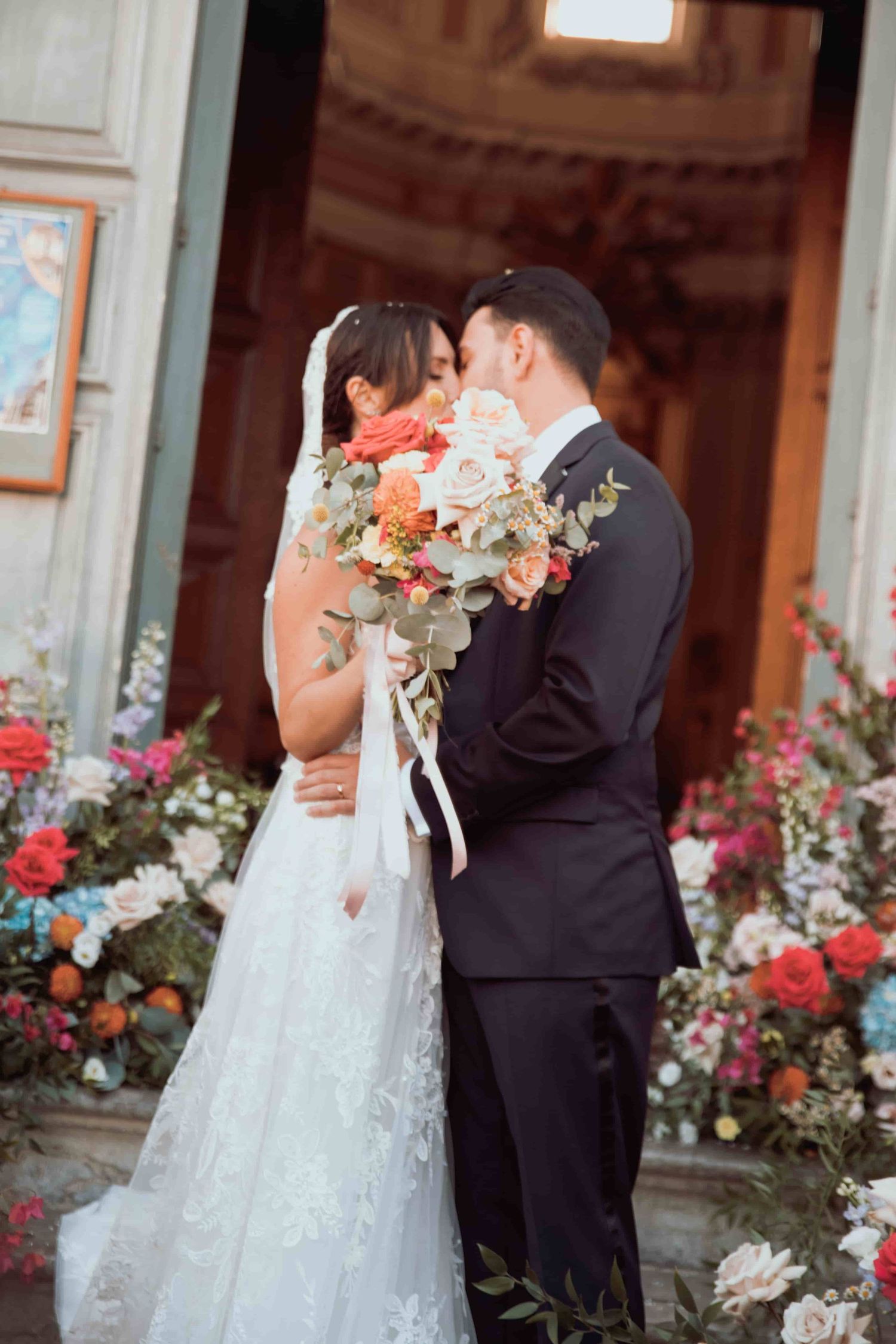 Romantic wedding moment captured in a garden setting with floral decorations.