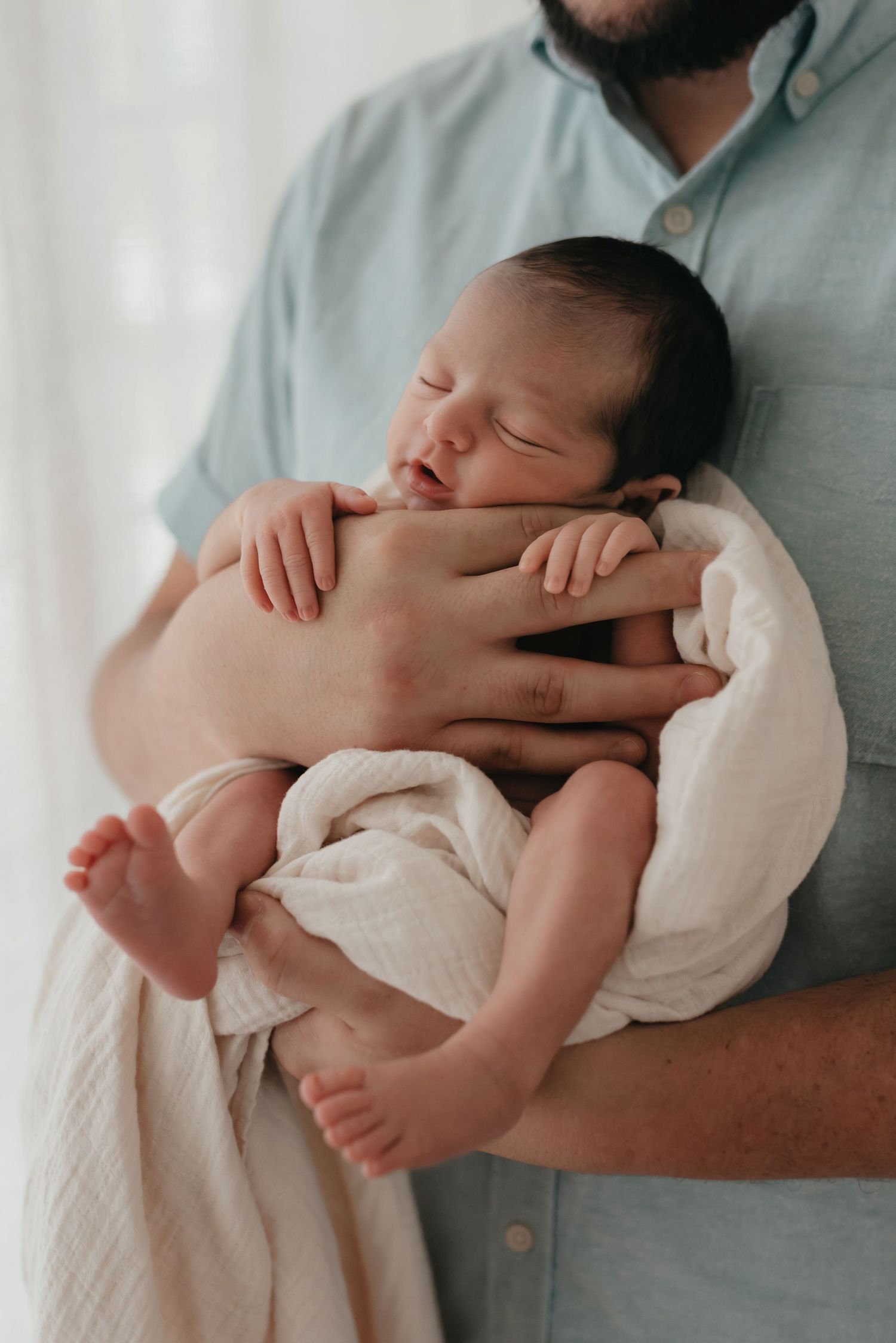 Posed newborn in studio session natural light parent portrait