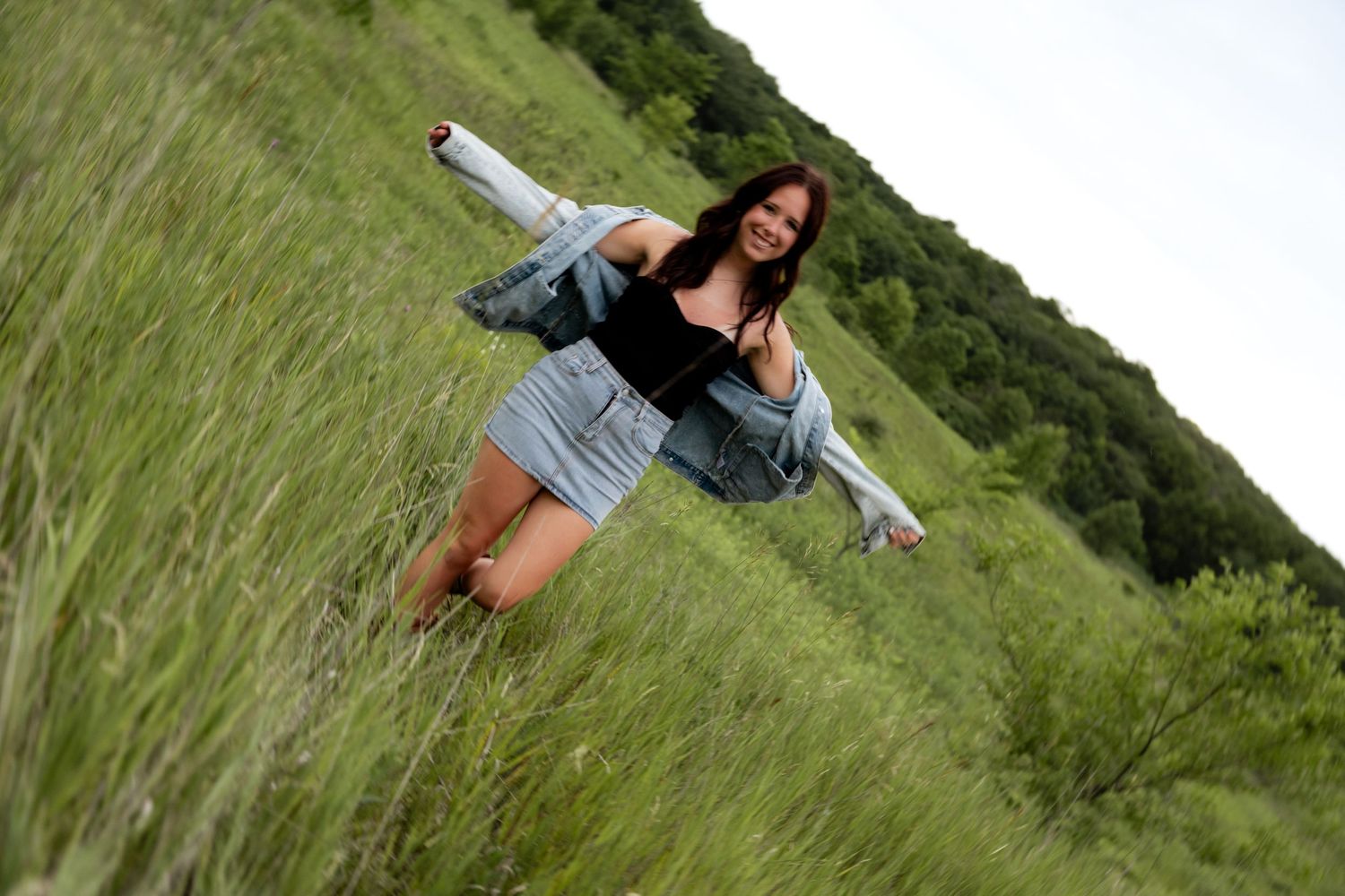 Casual summer portraits taken in a green field with natural lighting and rustic backdrop.