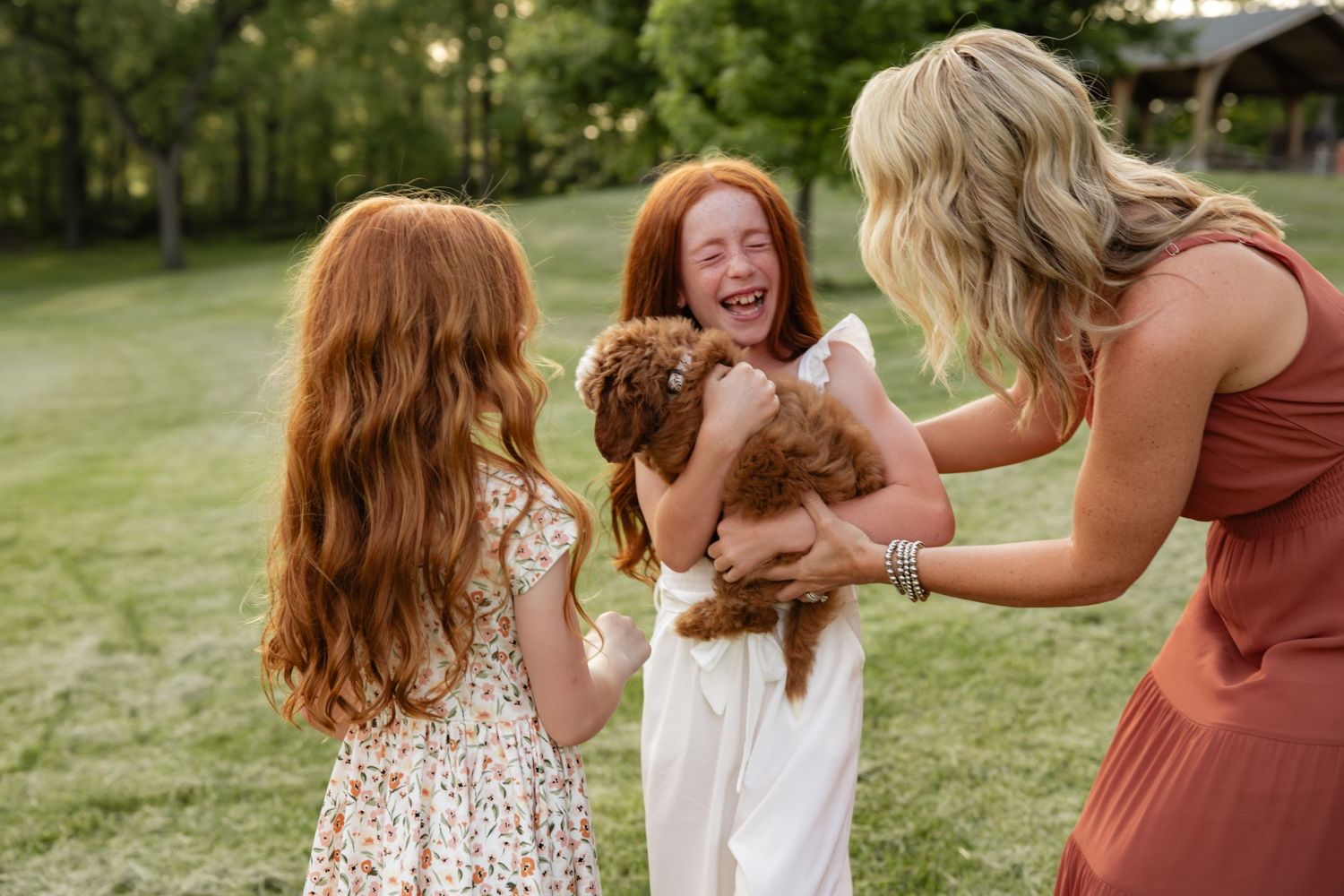 Playful interaction between family members in a green outdoor setting.