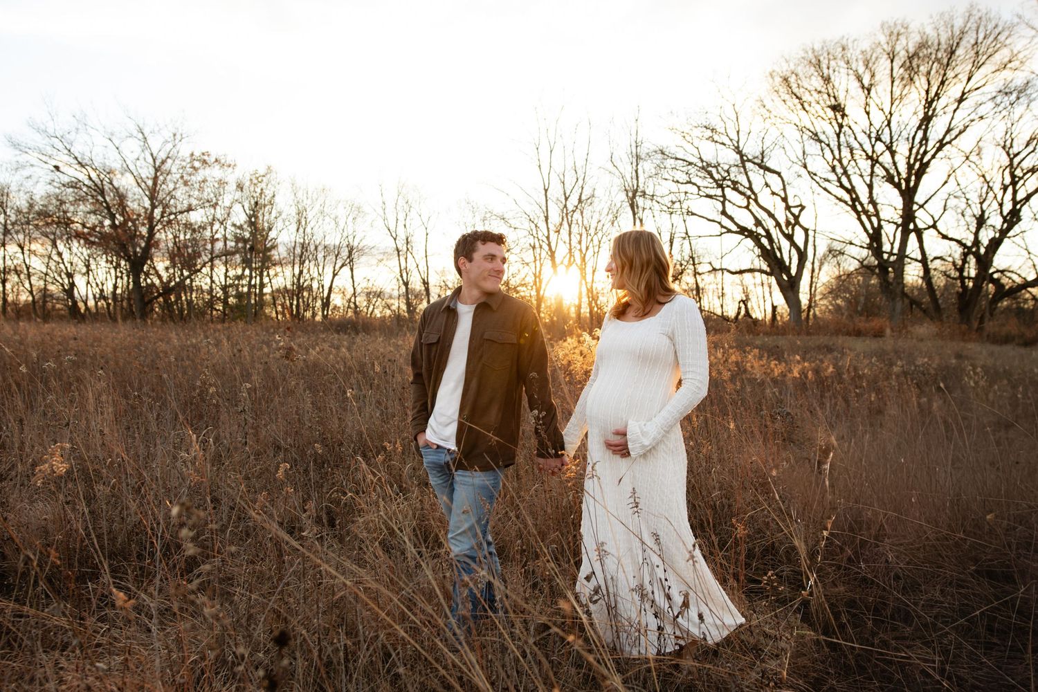 Romantic couple portrait session in golden field during sunset.