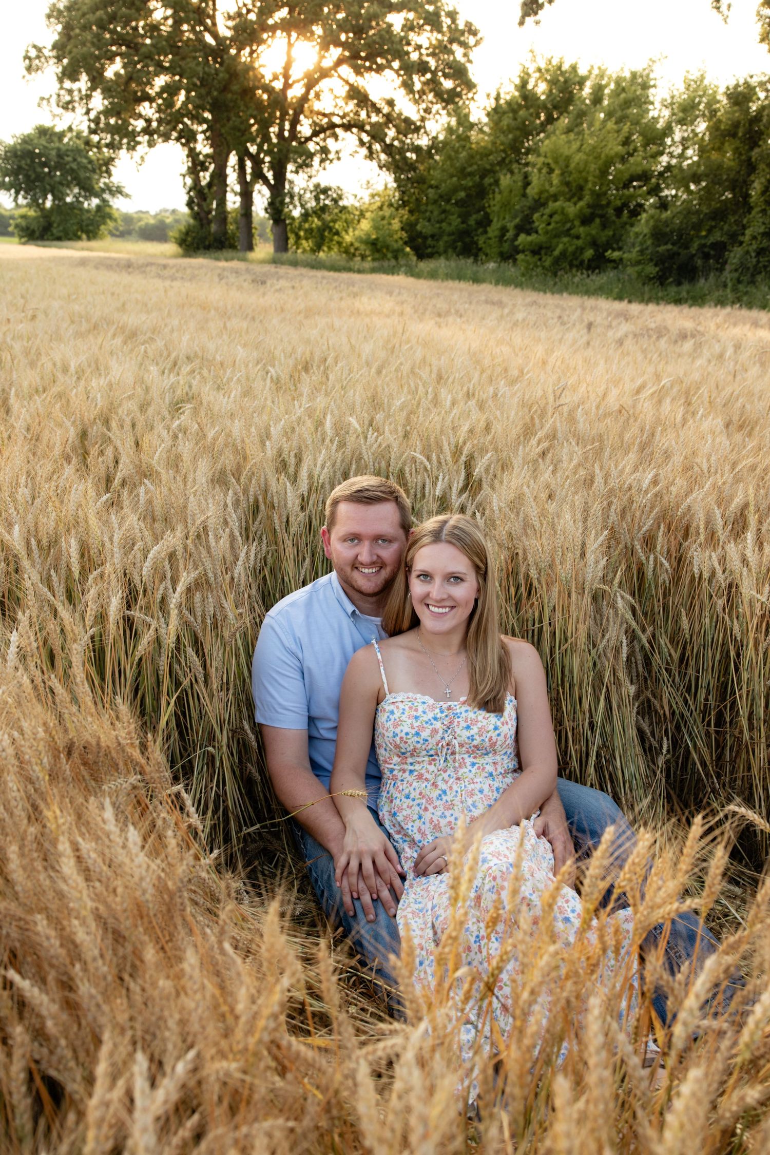 Engagement photos taken in a rustic wheat field during summer evening.