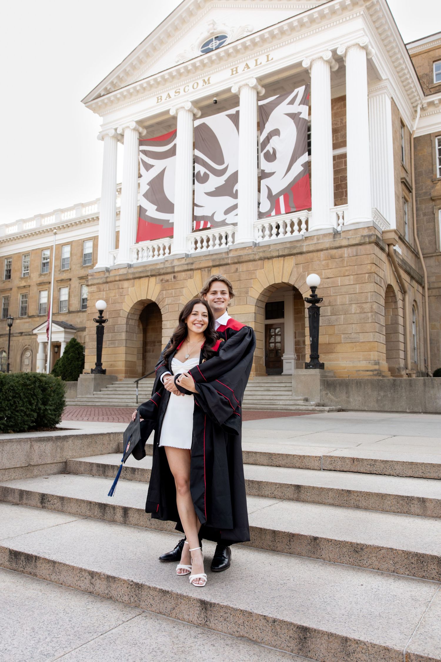 Celebratory graduation portraits captured on elegant stone steps with classical architecture backdrop.