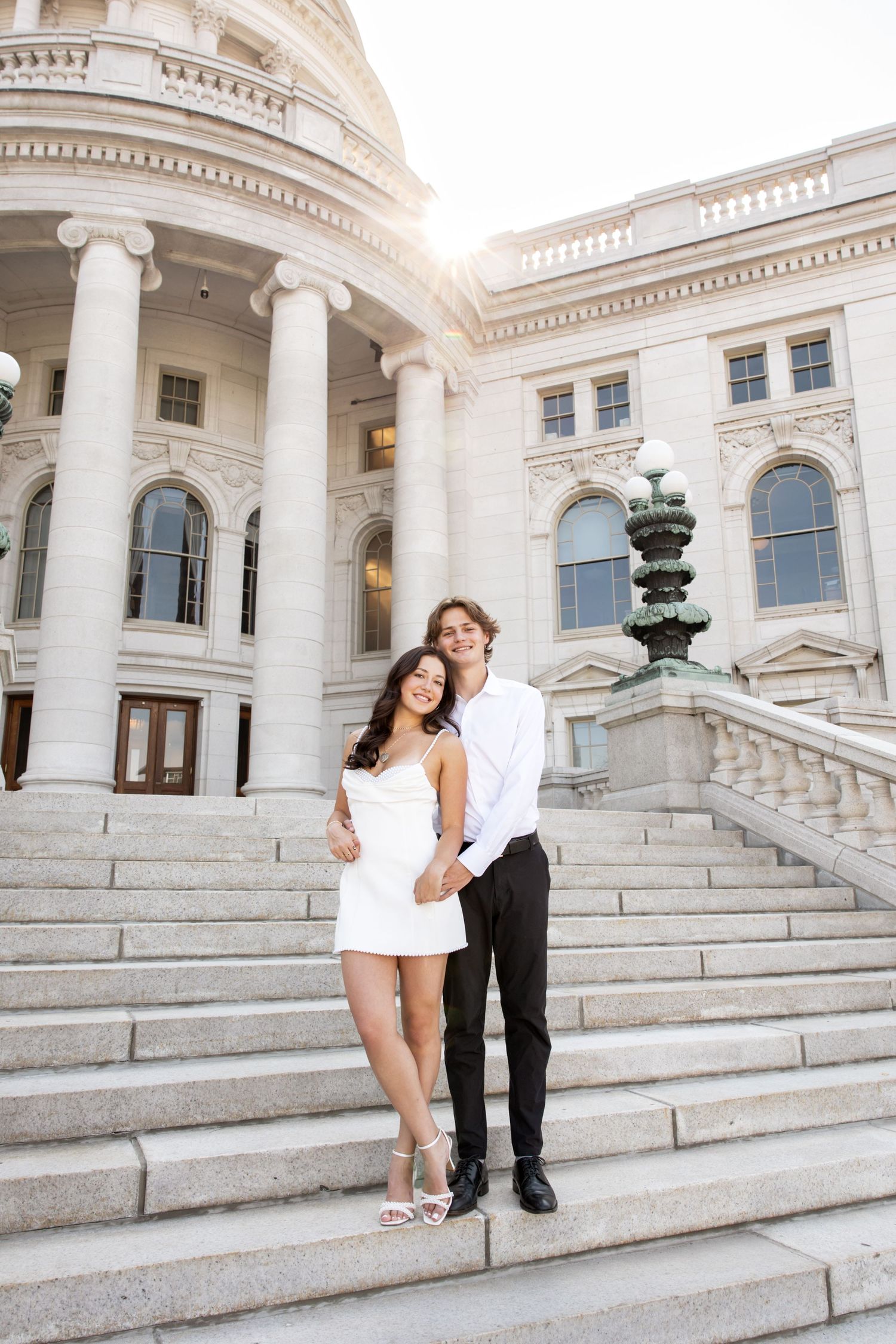 Playful engagement session photographed on majestic capitol building steps.