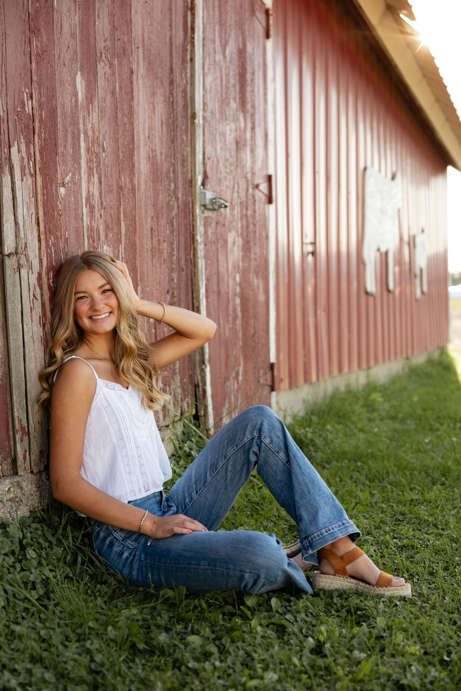 Casual portraits against rustic red barn wall in summer.