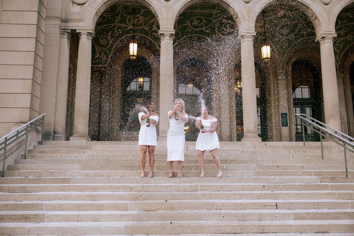 Series of dance photos showing performers in white dresses posing on stone steps of an ornate archway building.
