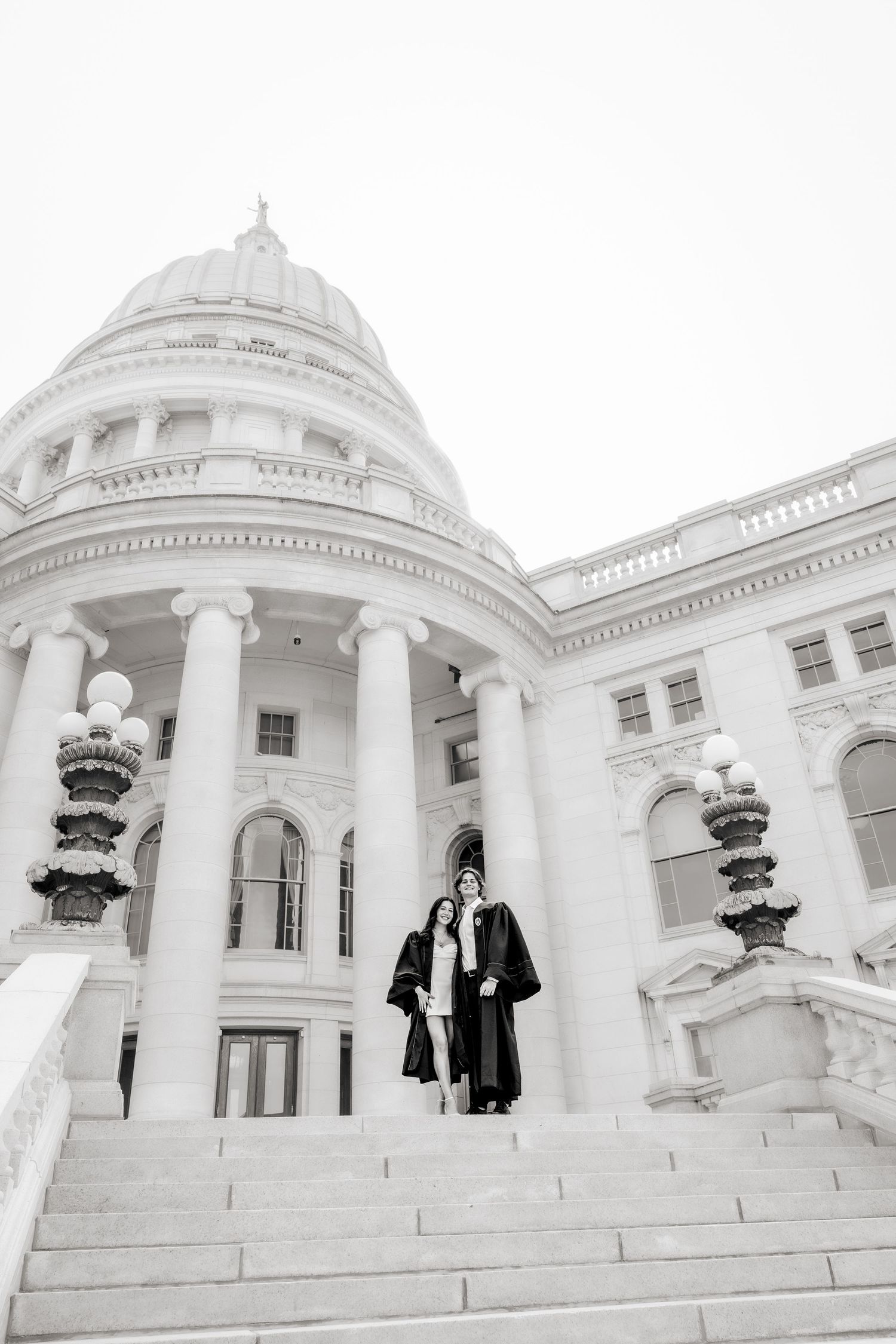 A black and white panoramic photograph showing a grand white domed building with classical architecture and stone steps.