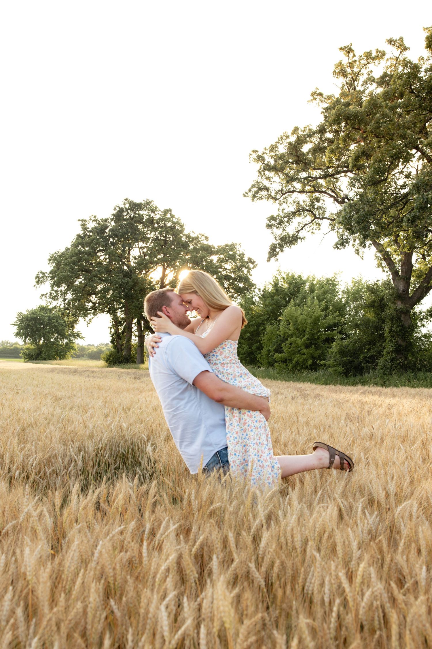 Romantic poses captured in a golden wheat field at sunset.