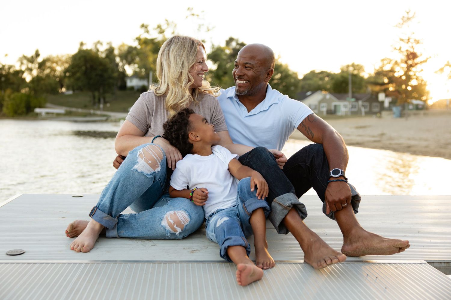 Intimate beach photoshoot at sunset with couple relaxing on dock.