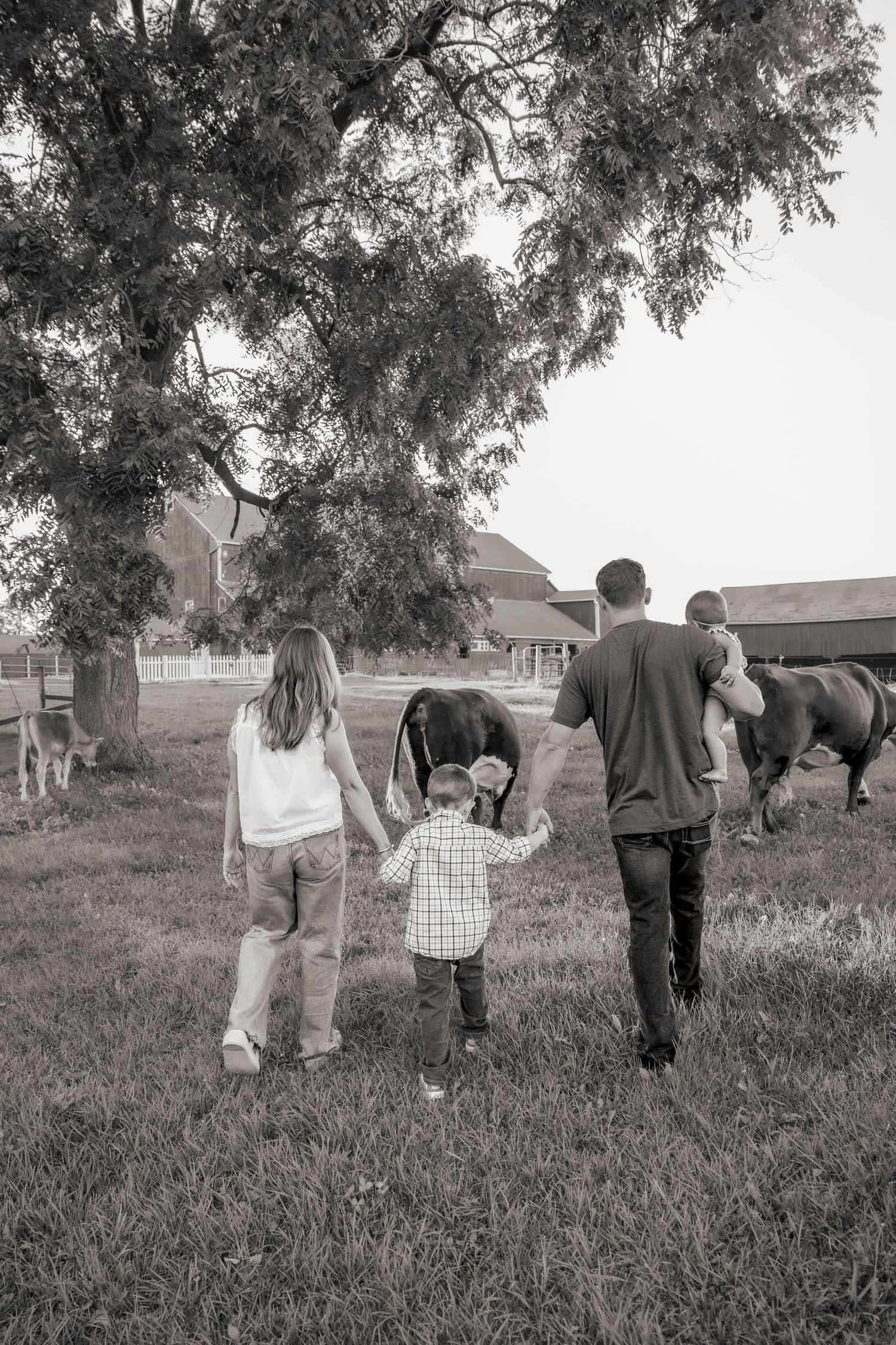 A group walks together through a grassy field in black and white photography.