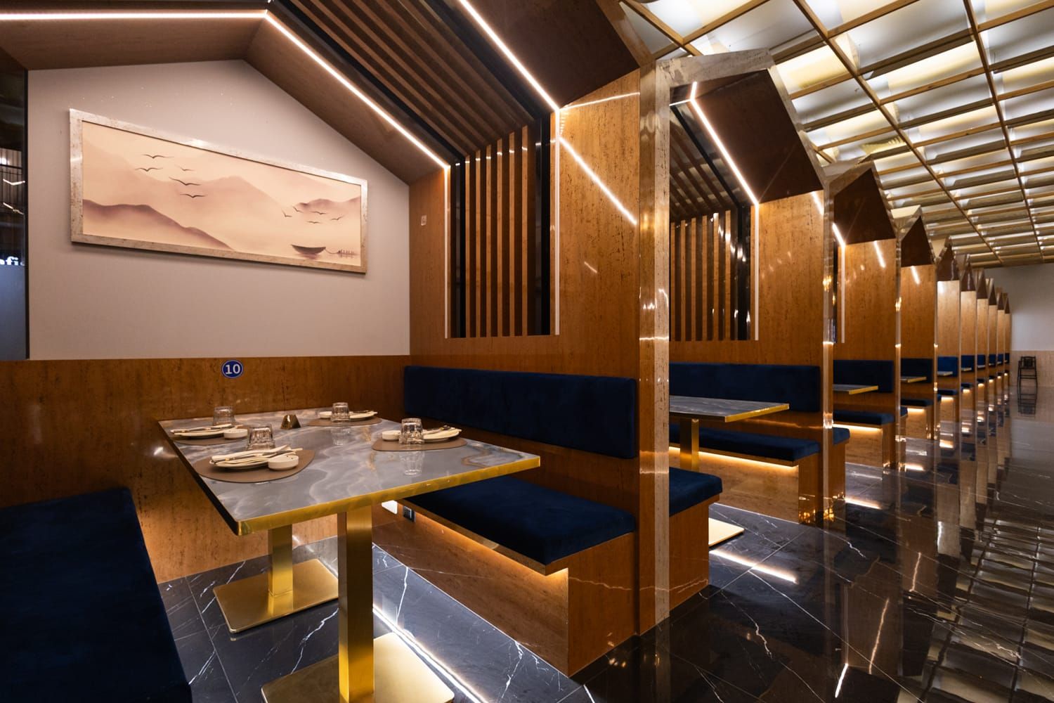 Ampia sala con pannellature in legno, file di comodi posti a sedere con luci calde a Trapani da Roku Sushi Restaurant.