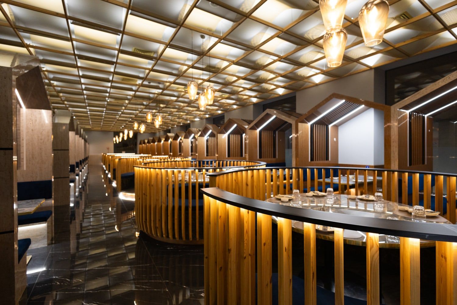 Roku Sushi restaurant Trapani, in Sicilia, sala con soffitto a doghe di legno, illuminazione e arredi eleganti formula All You Can Eat.