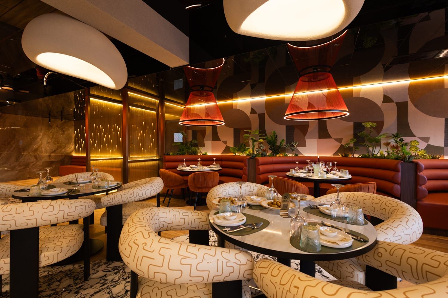 Moderna sala con luci calde e divanetti curvi a Barcellona Pozzo di Gotto del ristorante Roku Sushi Restaurant.