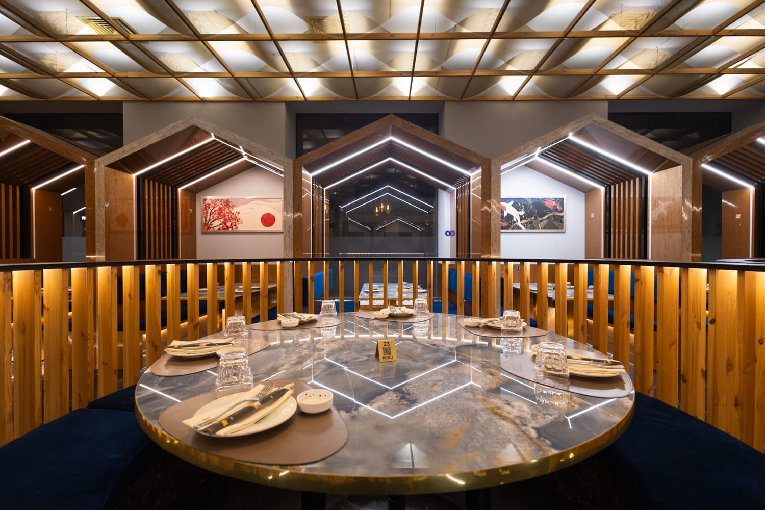 Elegante tavolo rotondo in un moderno divanetto con pannelli in legno a Trapani da Roku Sushi Restaurant con formula 