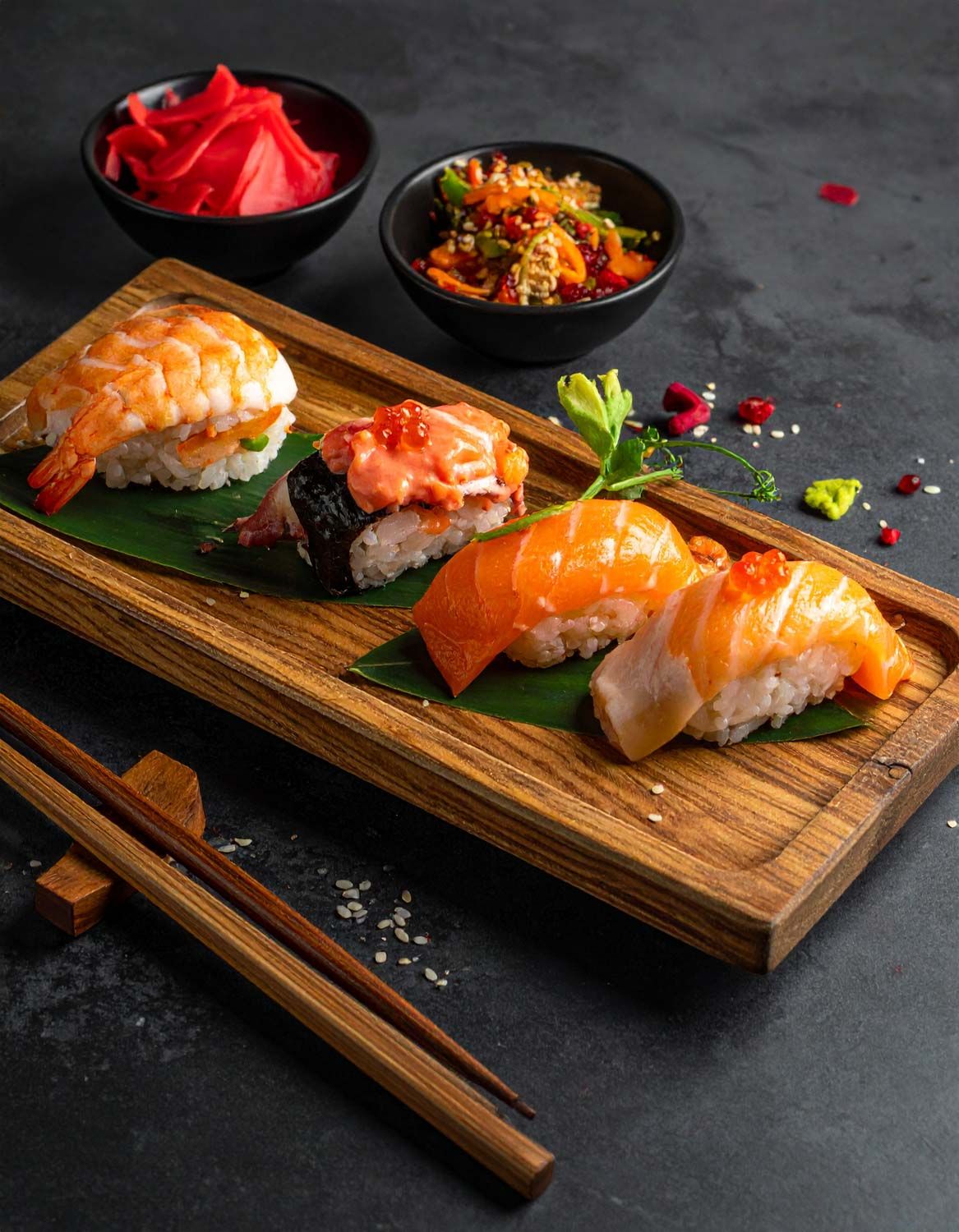 Eleganti sushi nigiri con salmone e gamberi serviti su un tagliere di legno con bacchette e guarnizioni su sfondo scuro.