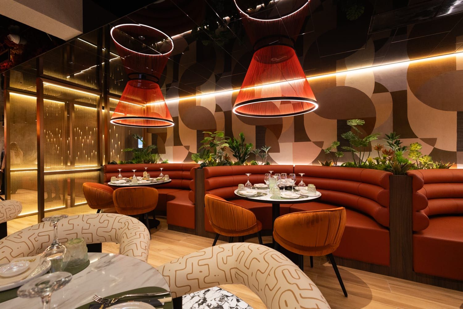 Sala con divanetti rossi curvi e grandi lampadari moderni a Barcellona Pozzo di Gotto, Sicilia, Roku Sushi Restaurant.