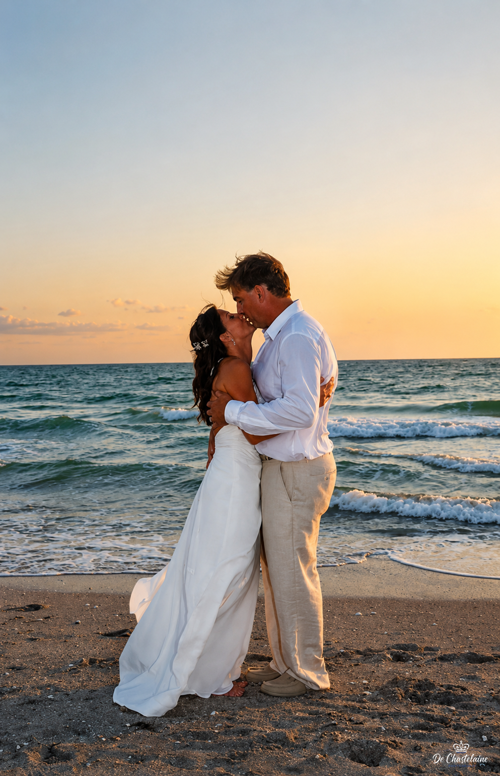 Bride and groom kissing at the beach sunset