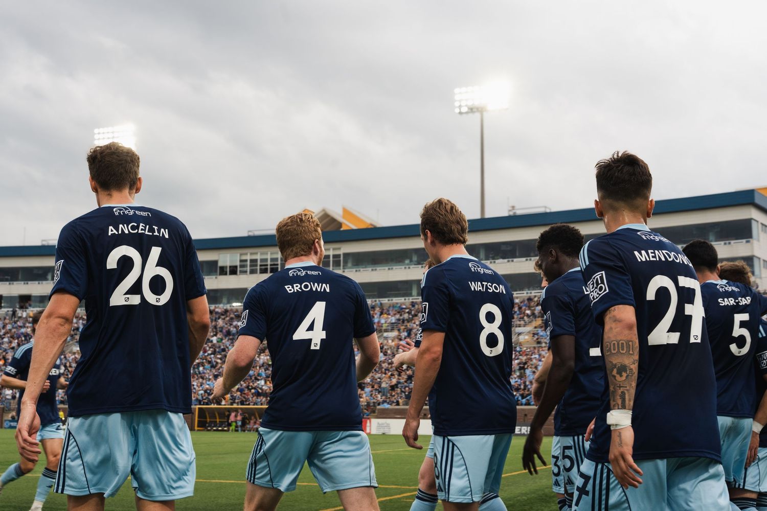 Chattanooga FC Soccer team in navy Adidas Teren jerseys walk onto field showing player name and numbers.