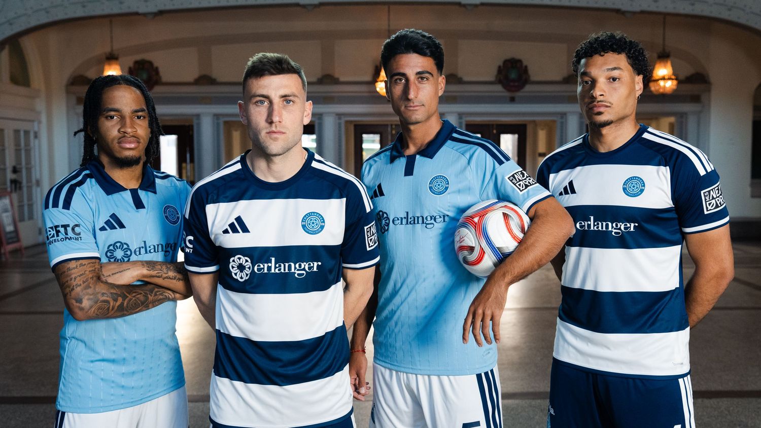 Four soccer players in team jerseys posing indoors photographed for a creative sports assignment in Chattanooga, TN.