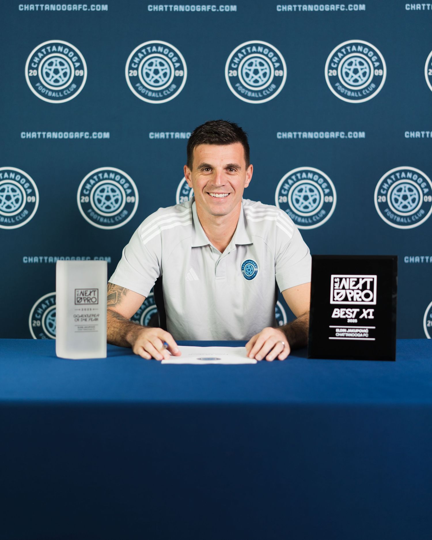 Chattanooga FC player smiles beside MLS Next Pro Best XI and Goalkeeper of the Year trophies. Photographed for Chattanooga FC player signing
