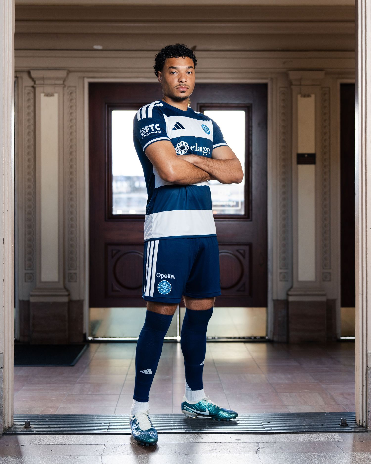 Chattanooga FC player stands confidently in navy with arms crossed photographed for a creative sports assignment in Chattanooga, TN.