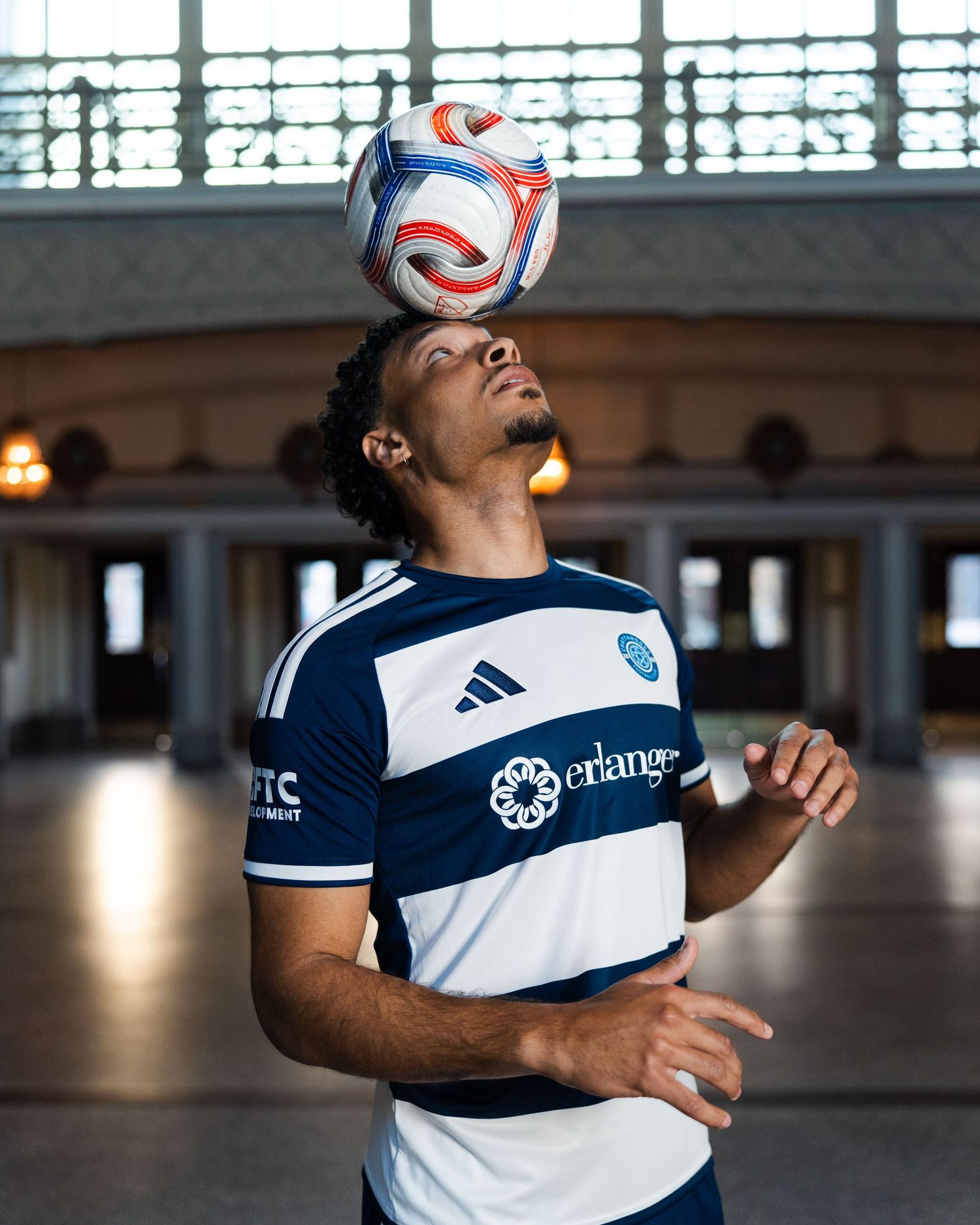 Chattanooga FC player balances soccer ball on head in Chattanooga Choo-Choo photographed for a creative sports assignment in Chattanooga, TN