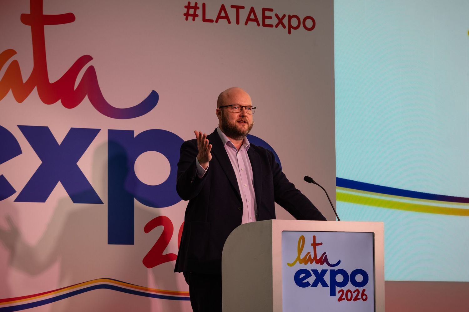 Male speaker presenting on stage at LATA Expo 2026 conference event.