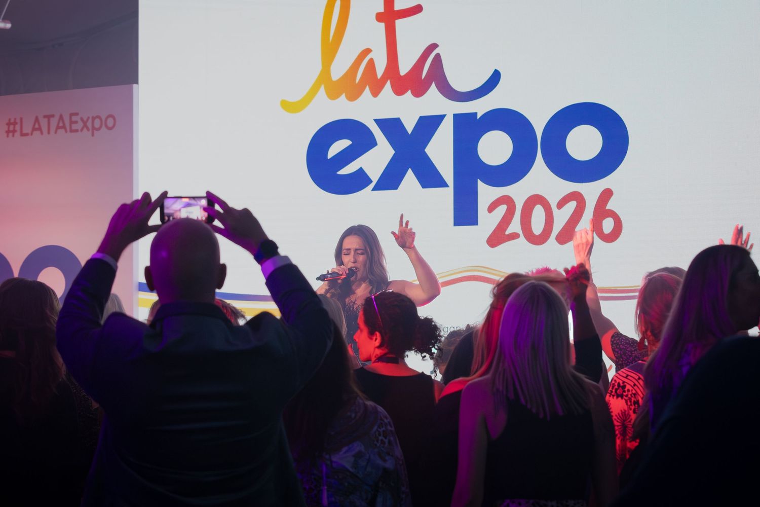 Crowd enjoying a live performance at LATA Expo 2026 under colorful stage lighting.