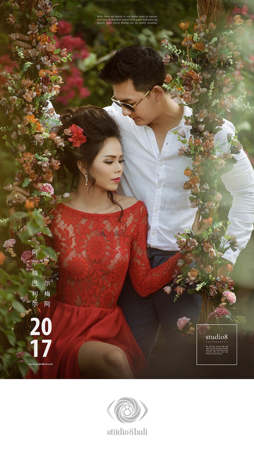 Romantic couple poses in floral garden, woman in red lace dress with flower in hair, man in white shirt, 2017 studio8bali photo.