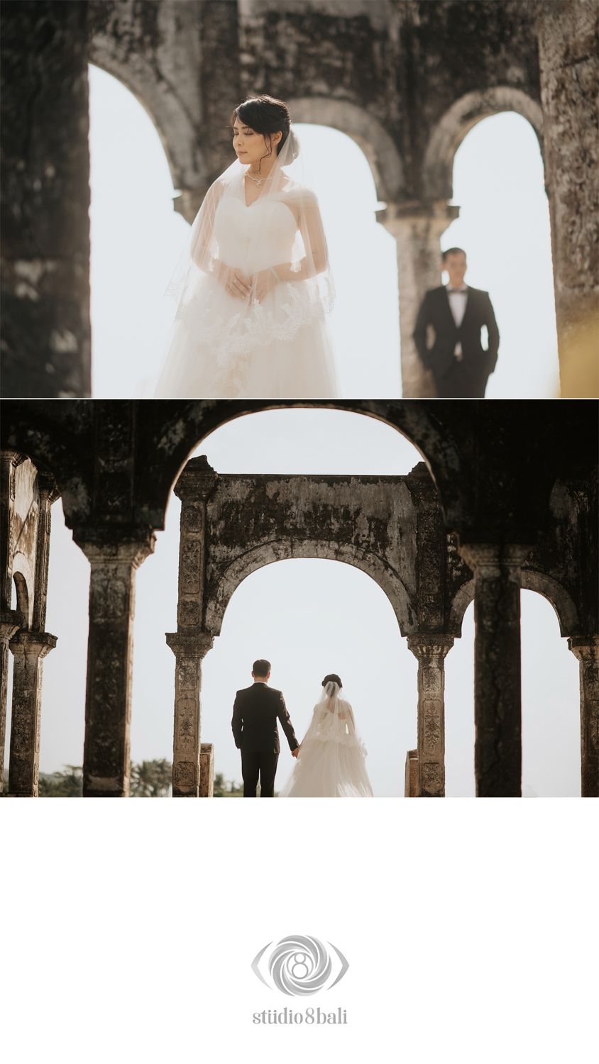 Bride in white gown and groom in tuxedo pose at ancient stone archway ruins in romantic wedding photography by Studio 8 Bali.