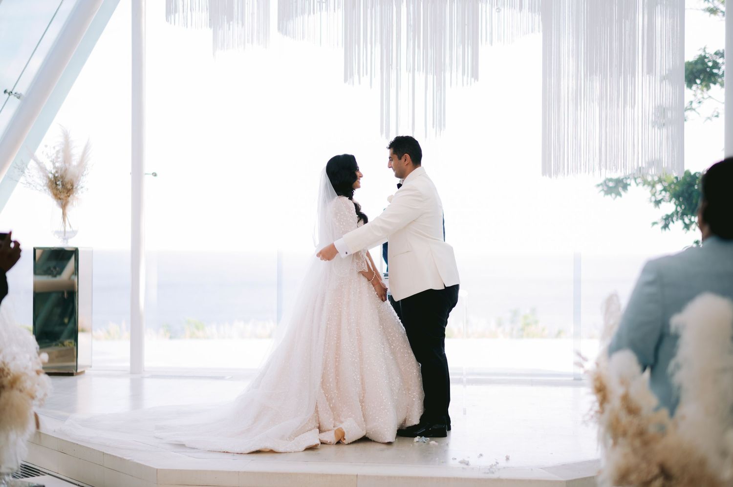 Bride and groom share first dance at elegant wedding ceremony with white draping and panoramic views.