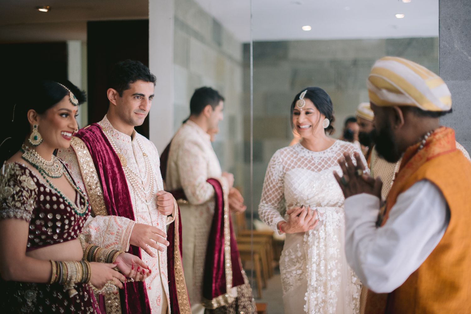 Indian wedding guests in traditional attire greet each other during a vibrant ceremony celebration.