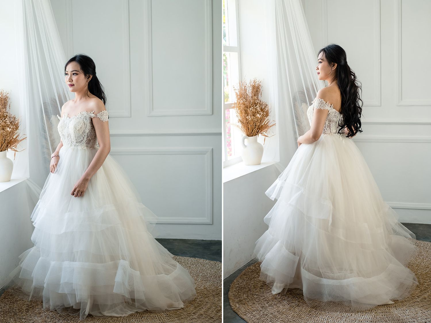 Bride in off-shoulder tiered tulle ball gown with lace bodice posing by window in soft natural light.