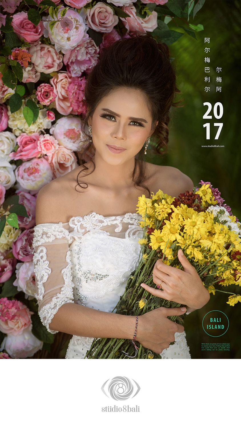 A bride in white lace dress holds yellow flowers against a pink rose backdrop in a 2017 Bali Island studio portrait.