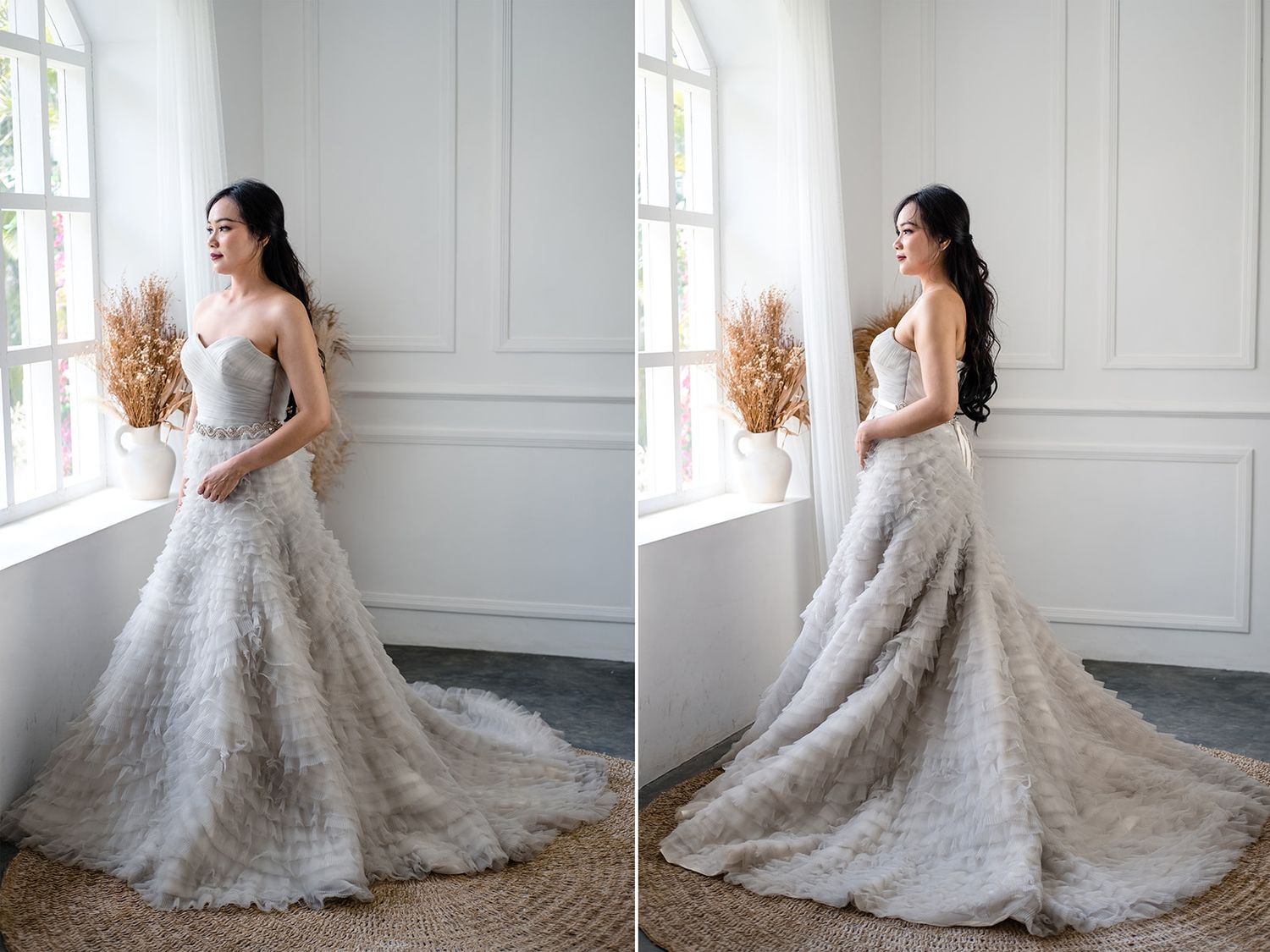 Elegant bride in a strapless lace wedding gown with a long train, posing near a bright window in a white studio.