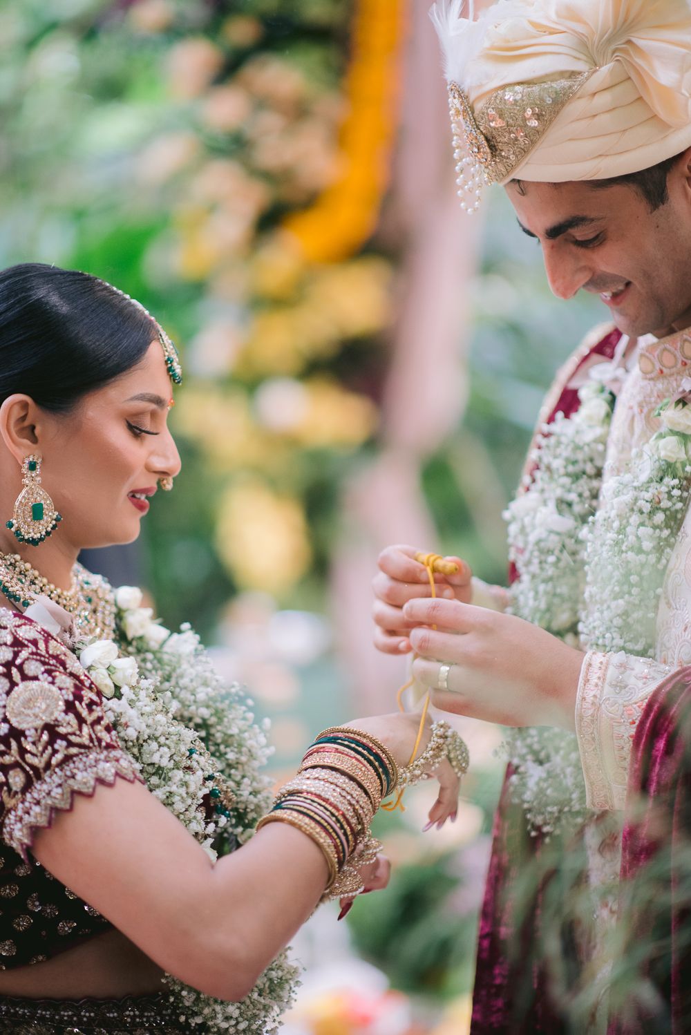 Indian bride and groom exchanging garlands during traditional Hindu wedding ceremony in elegant bridal attire.